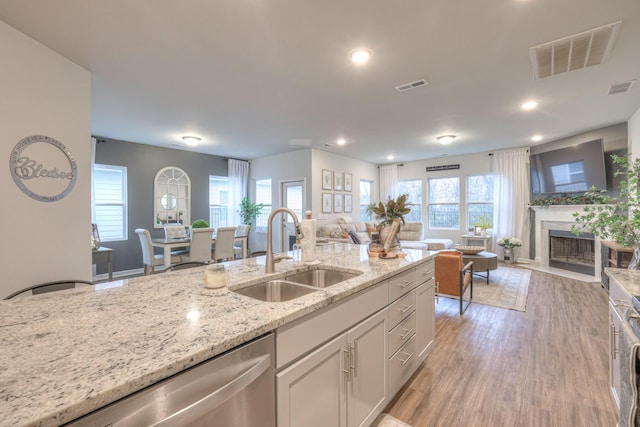 kitchen featuring open floor plan, visible vents, a sink, and dishwasher