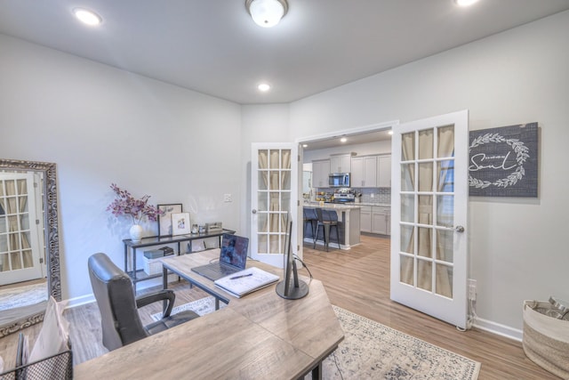 home office featuring light wood finished floors, french doors, recessed lighting, and baseboards