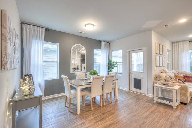 dining room with light wood finished floors, visible vents, and baseboards