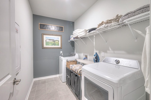 laundry area with laundry area, light tile patterned floors, baseboards, and washer and dryer