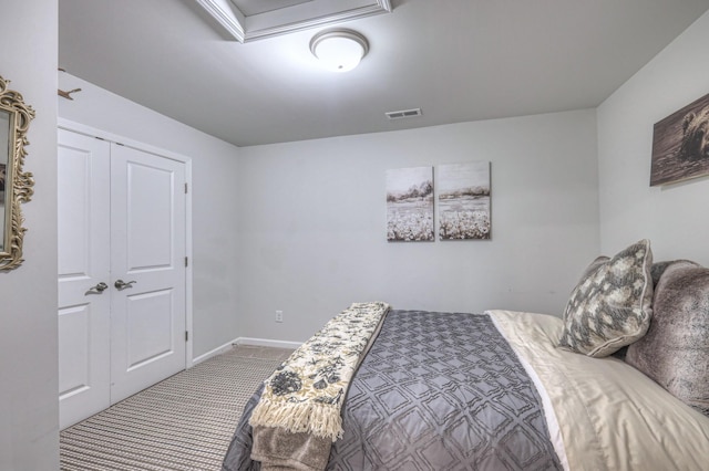 carpeted bedroom featuring baseboards and visible vents