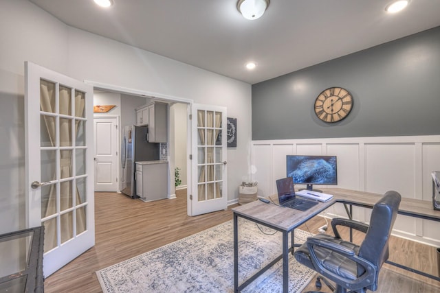 home office with french doors, recessed lighting, a decorative wall, light wood-style flooring, and wainscoting