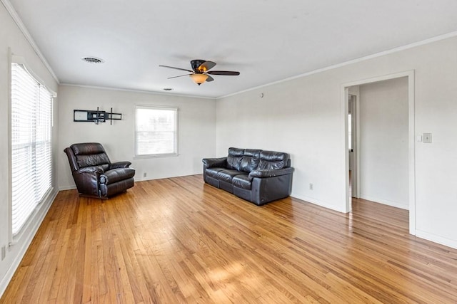 sitting room featuring light wood-style floors, a healthy amount of sunlight, visible vents, and crown molding