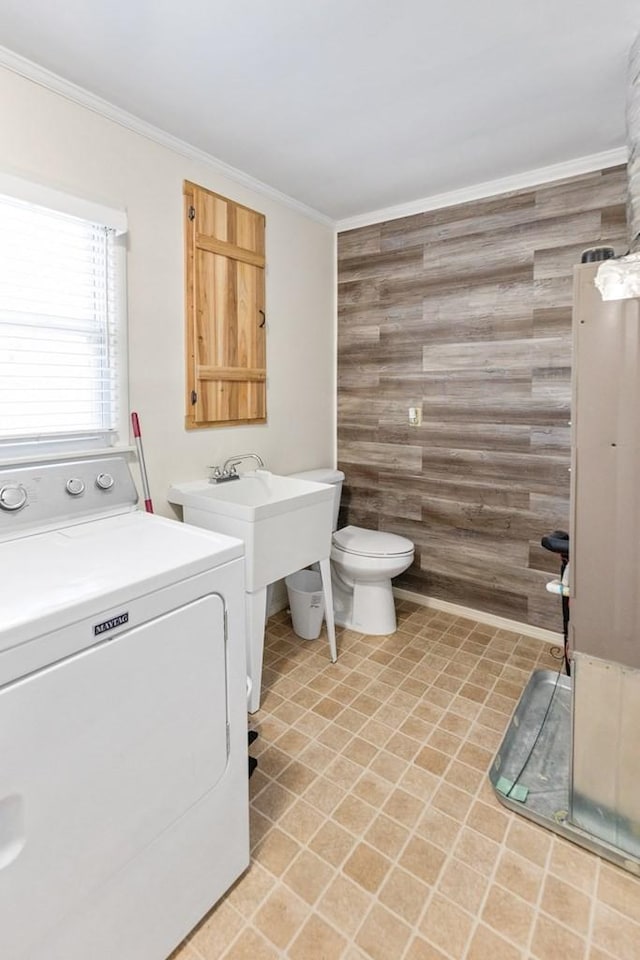 full bathroom with washer / dryer, a sink, crown molding, and toilet