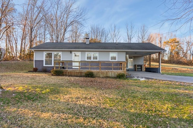 view of front of property with a chimney, aphalt driveway, a wooden deck, a front lawn, and a carport