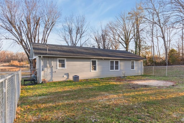 rear view of property featuring a fenced backyard, a lawn, and central air condition unit