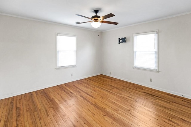 empty room with ornamental molding, baseboards, ceiling fan, and light wood finished floors