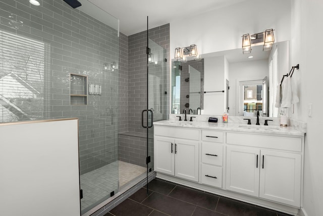 full bathroom with a stall shower, tile patterned flooring, a sink, and double vanity