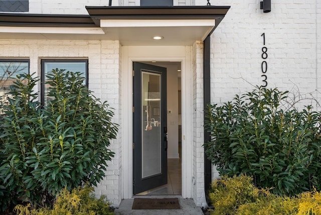 view of exterior entry with brick siding