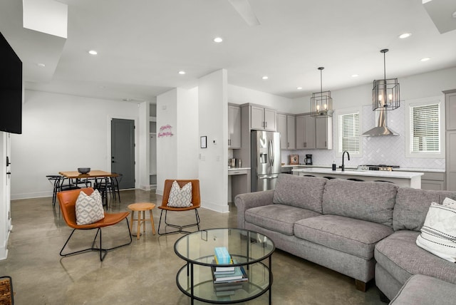 living area featuring baseboards, concrete flooring, and recessed lighting