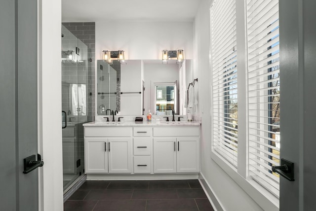 full bathroom featuring a sink, double vanity, tile patterned flooring, and a shower stall