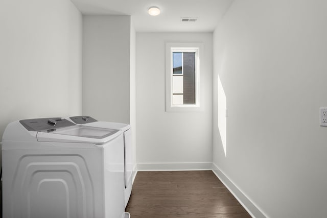 laundry area featuring dark wood finished floors, visible vents, laundry area, independent washer and dryer, and baseboards