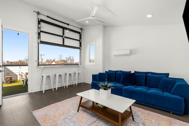 living area featuring recessed lighting, wood finished floors, a ceiling fan, baseboards, and a wall mounted air conditioner