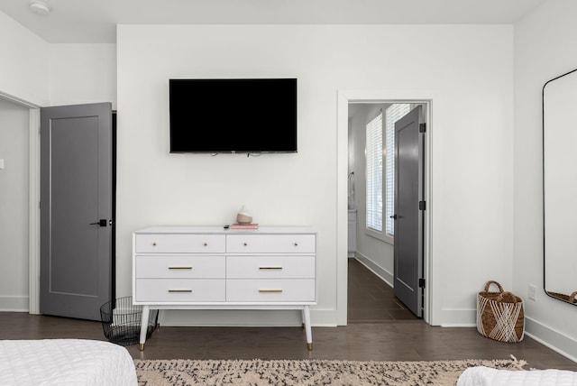 bedroom with dark wood finished floors and baseboards