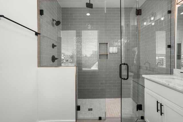 bathroom featuring a shower stall and vanity