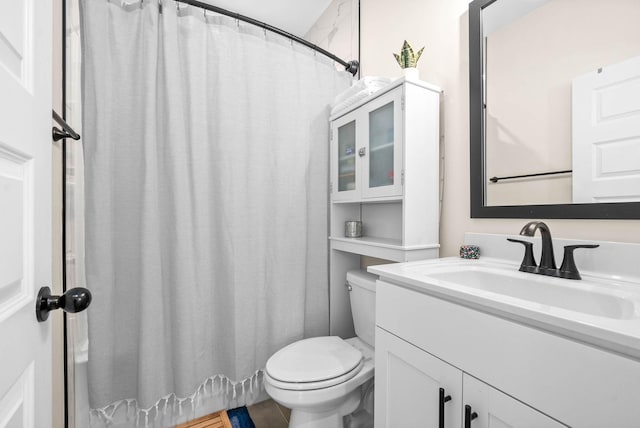 bathroom with a shower with shower curtain, vanity, and toilet