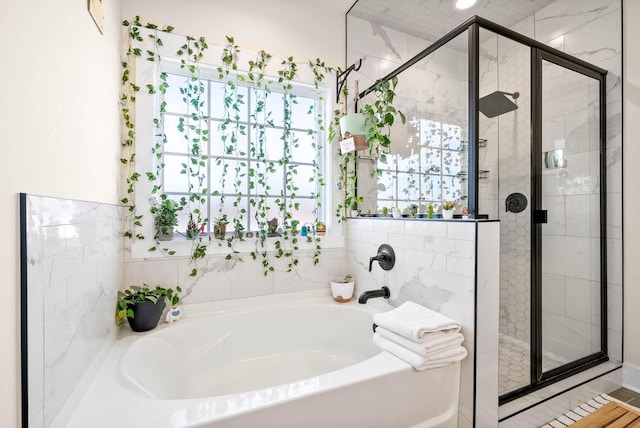 bathroom with a shower stall and a bath