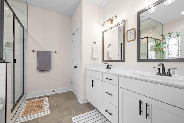 bathroom with a sink, a shower stall, baseboards, and double vanity