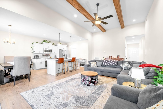 living room with visible vents, ceiling fan with notable chandelier, light wood-type flooring, beam ceiling, and recessed lighting