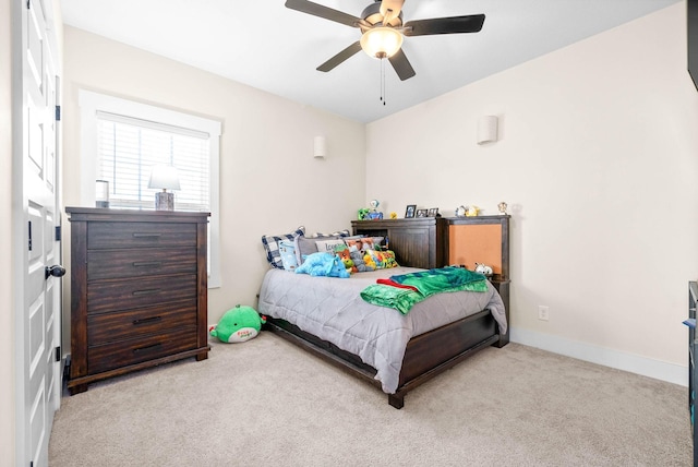 carpeted bedroom featuring baseboards and a ceiling fan