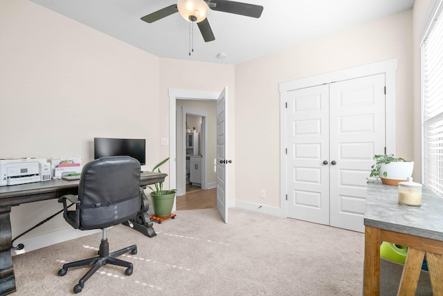 carpeted home office featuring a ceiling fan and baseboards