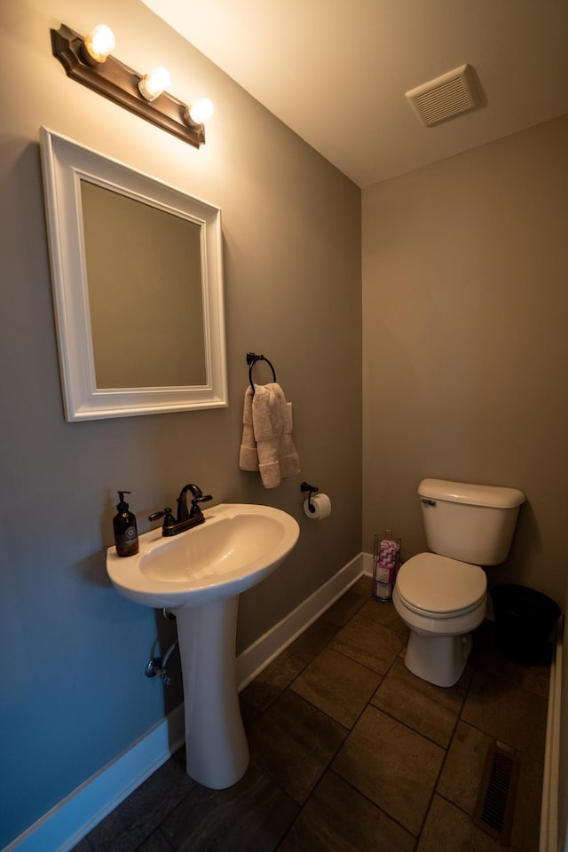 bathroom with baseboards, visible vents, and toilet