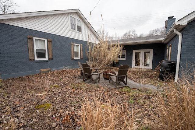 view of yard with an outdoor fire pit and french doors