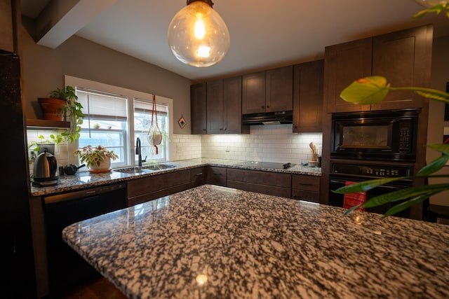 kitchen featuring under cabinet range hood, a sink, backsplash, black appliances, and dark stone countertops