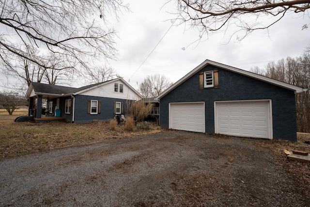 view of home's exterior featuring a garage, brick siding, and an outdoor structure