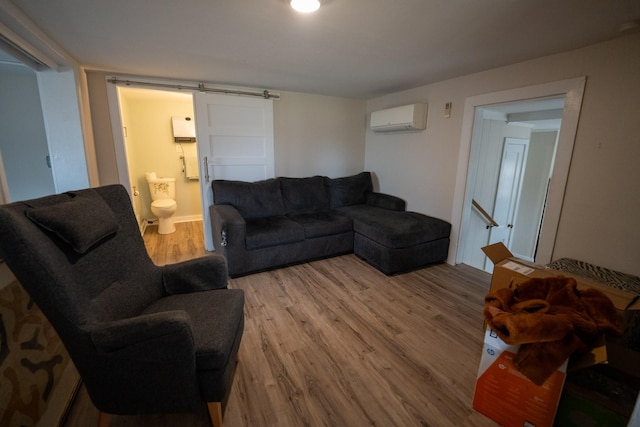 living room featuring wood finished floors, a barn door, and a wall mounted AC