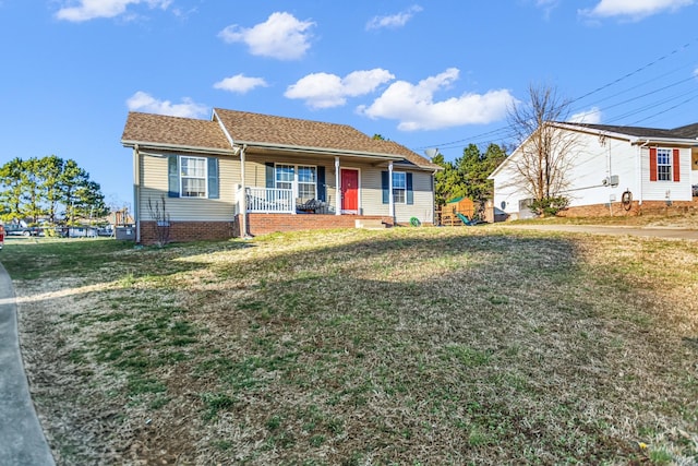 ranch-style house featuring covered porch and a front yard