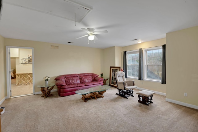 living area with attic access, visible vents, carpet floors, and baseboards