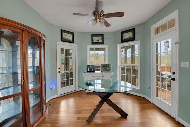 unfurnished sunroom with visible vents, a ceiling fan, and french doors