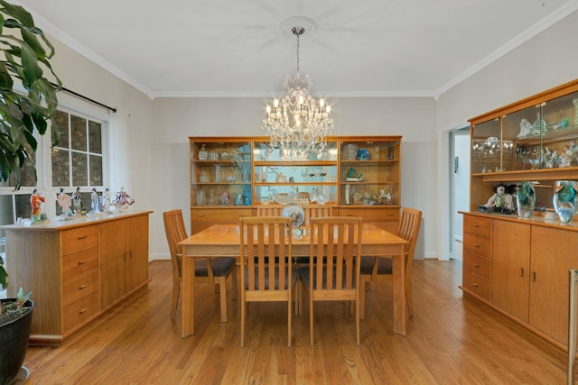 dining room with light wood-style floors, a chandelier, and crown molding