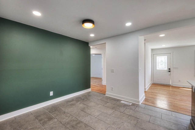 unfurnished room with recessed lighting, visible vents, and baseboards