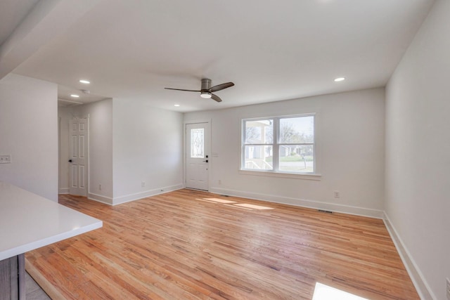 unfurnished living room featuring light wood finished floors, visible vents, and baseboards