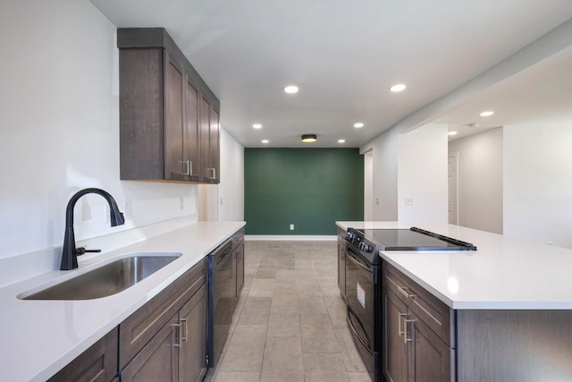 kitchen with black appliances, dark brown cabinets, a sink, and light countertops