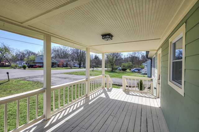 wooden terrace featuring a residential view and a porch