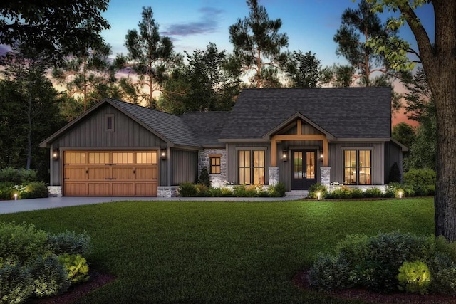 modern farmhouse featuring driveway, a garage, a shingled roof, stone siding, and a front lawn