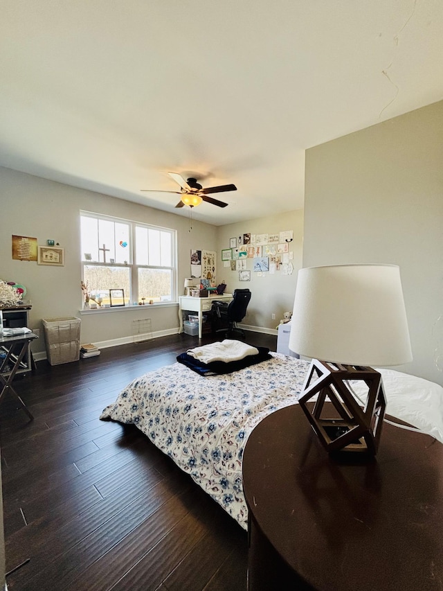 bedroom with ceiling fan, baseboards, and dark wood-style flooring