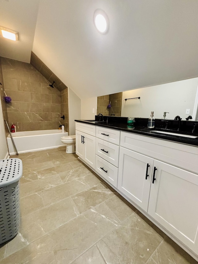 full bath with toilet, shower / bath combination, a sink, vaulted ceiling, and double vanity