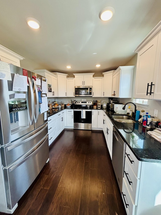 kitchen featuring dark wood-style floors, recessed lighting, appliances with stainless steel finishes, white cabinets, and a sink