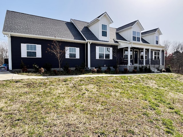 view of front of property featuring a shingled roof, a porch, and a front yard