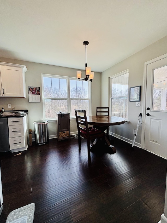 dining space featuring an inviting chandelier, baseboards, and dark wood finished floors