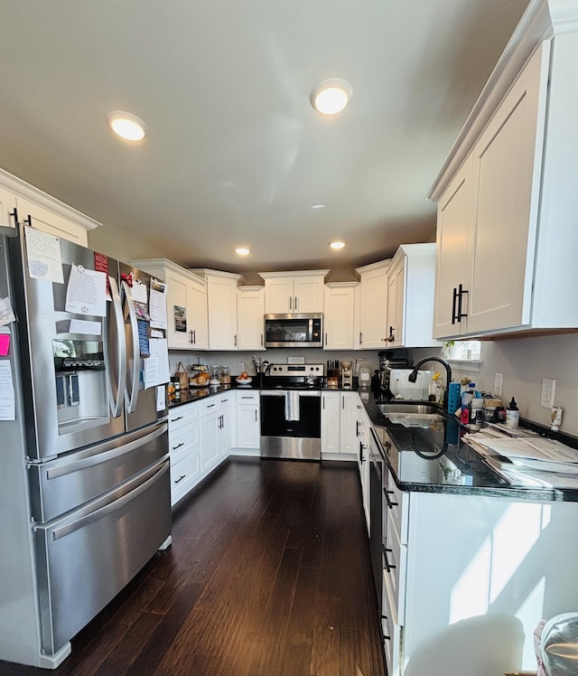 kitchen with recessed lighting, stainless steel appliances, a sink, white cabinetry, and dark wood-style floors