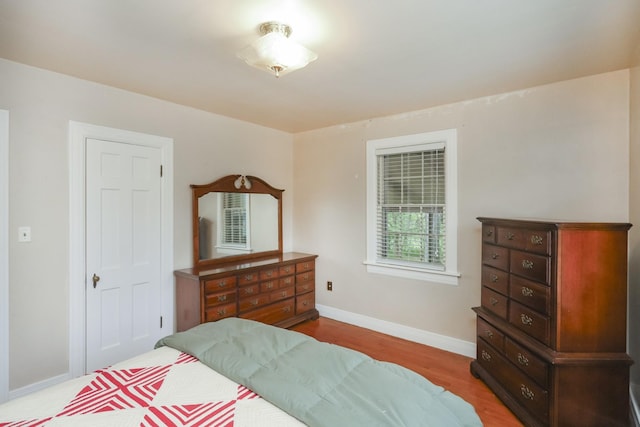 bedroom with baseboards and wood finished floors