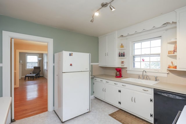 kitchen with freestanding refrigerator, black dishwasher, a sink, and open shelves