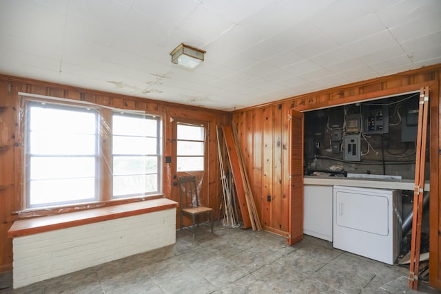 interior space with laundry area, wood walls, and washer and dryer