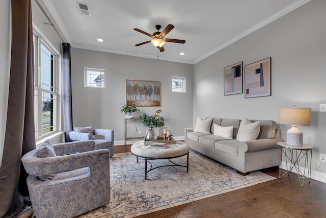 living room featuring visible vents, a healthy amount of sunlight, dark wood-type flooring, and ornamental molding