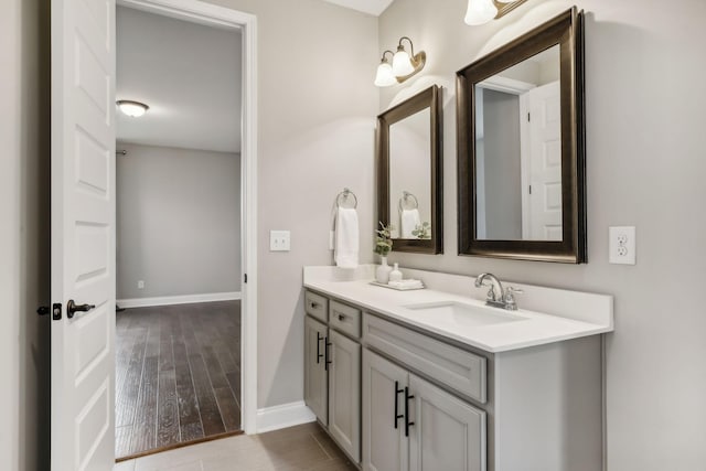 bathroom featuring baseboards, wood finished floors, and vanity